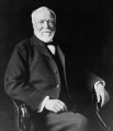 800px-Andrew Carnegie, three-quarter length portrait, seated, facing slightly left, 1913.jpg